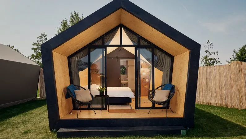 The exterior of the deluxe suite at Lost Village, a pentagonal pod with a floor to ceiling glass front.