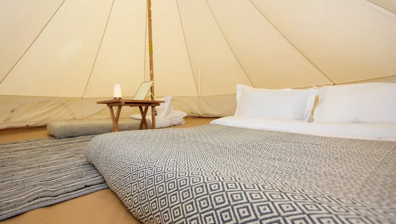 A photograph of the interior of the classic bell tent, a premium accommodation option at Lost Village.