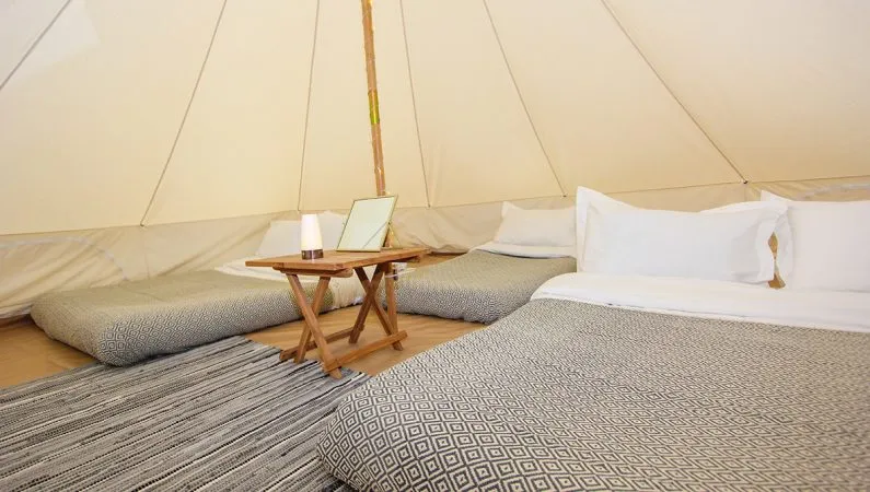 A photograph of the interior of the classic bell tent, a premium accommodation option at Lost Village.