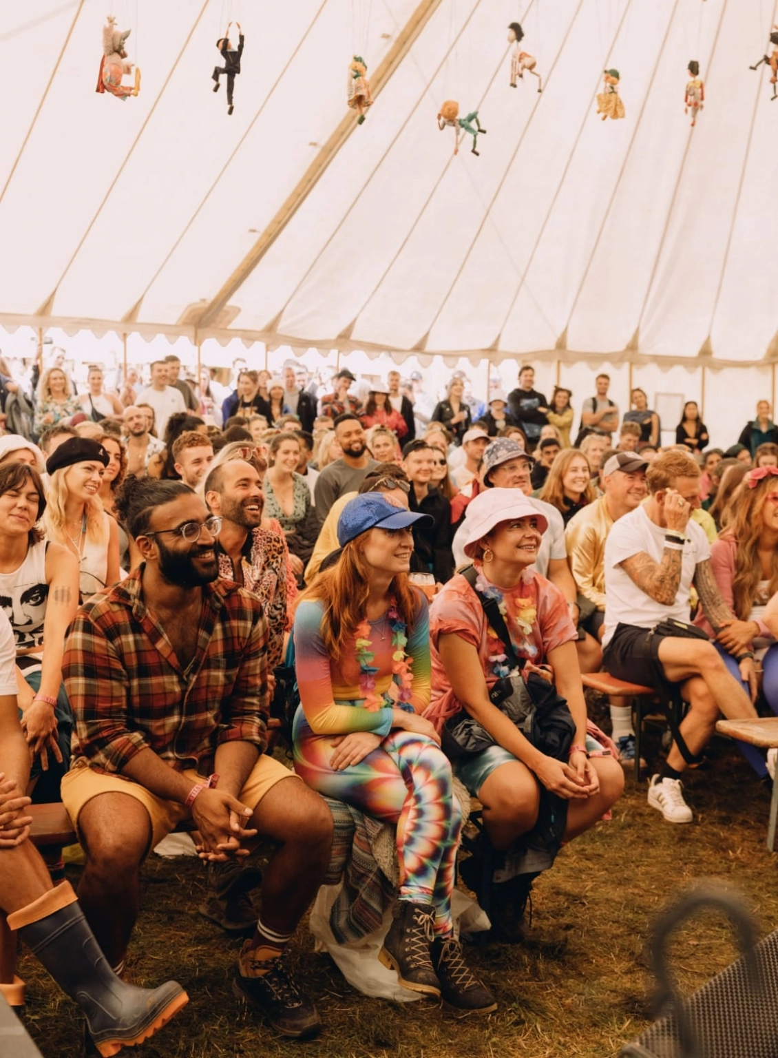 A crowd of people laughing as they listen to a comedy act at Lost Village.