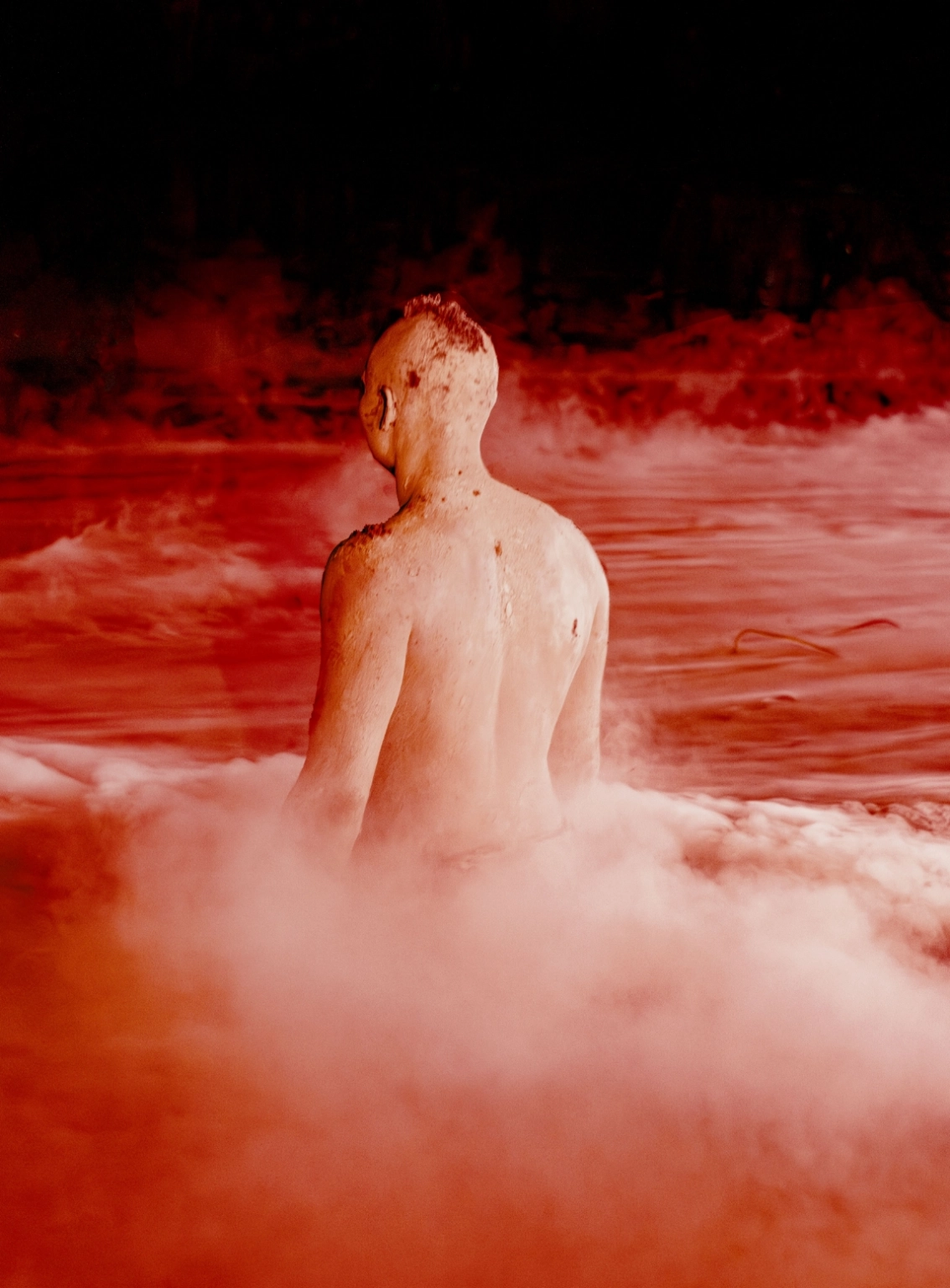 A cinematic photograph of a man immersed to his waist in water at Lost Village.