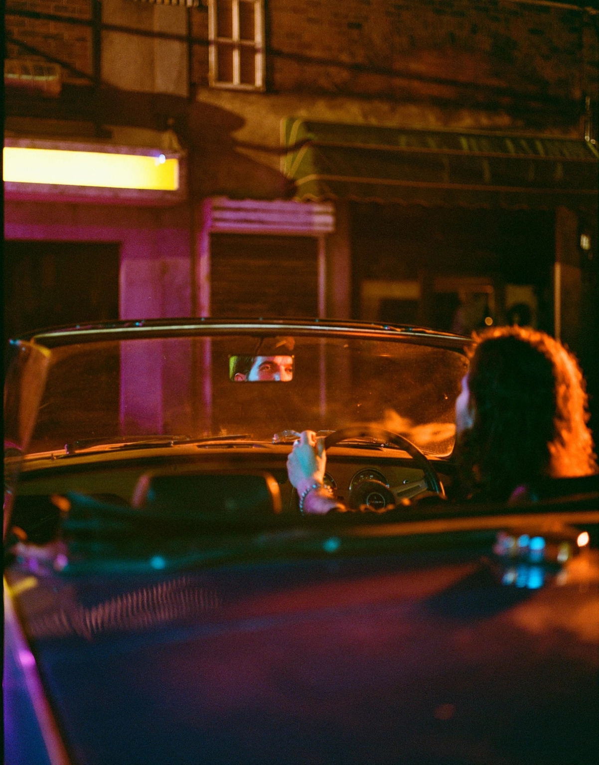 A photograph of a person sat in a vintage car set at Lost Village.
