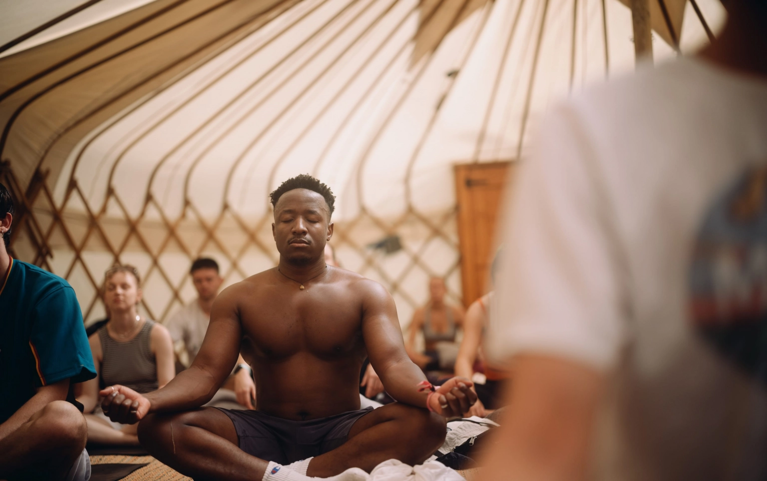 A photograph of people meditating in a tent at Lost Village.