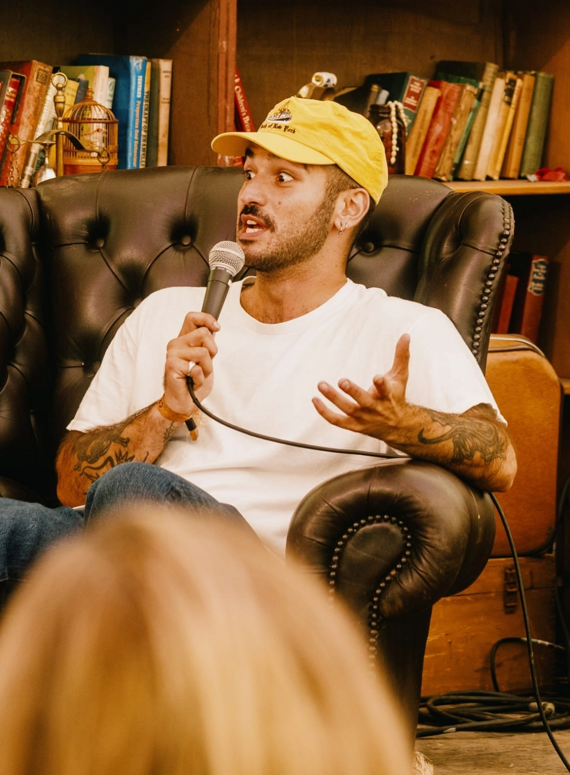 A person sat in an armchair delivering one of the talks at the Institute of Curious Minds at Lost Village.