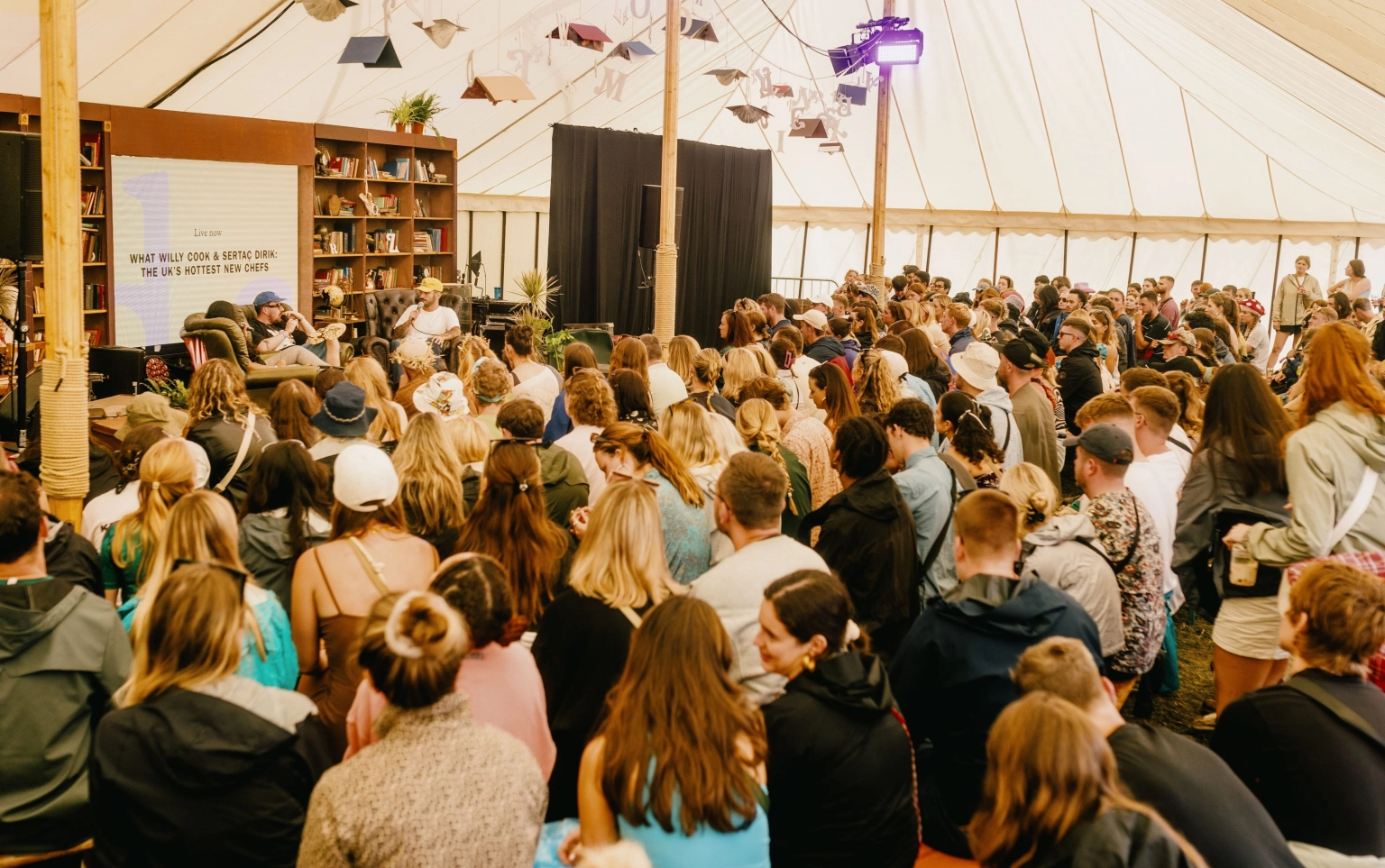 A photograph of a crowd listening to talks at the Institute of Curious Minds at Lost Village.