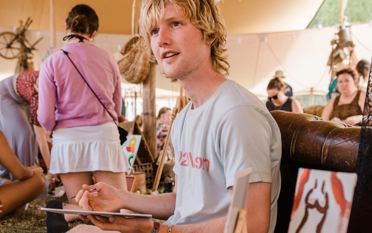 A photograph of how a creative workshop at Lost Village looks, with people handling painting and sketching tools.