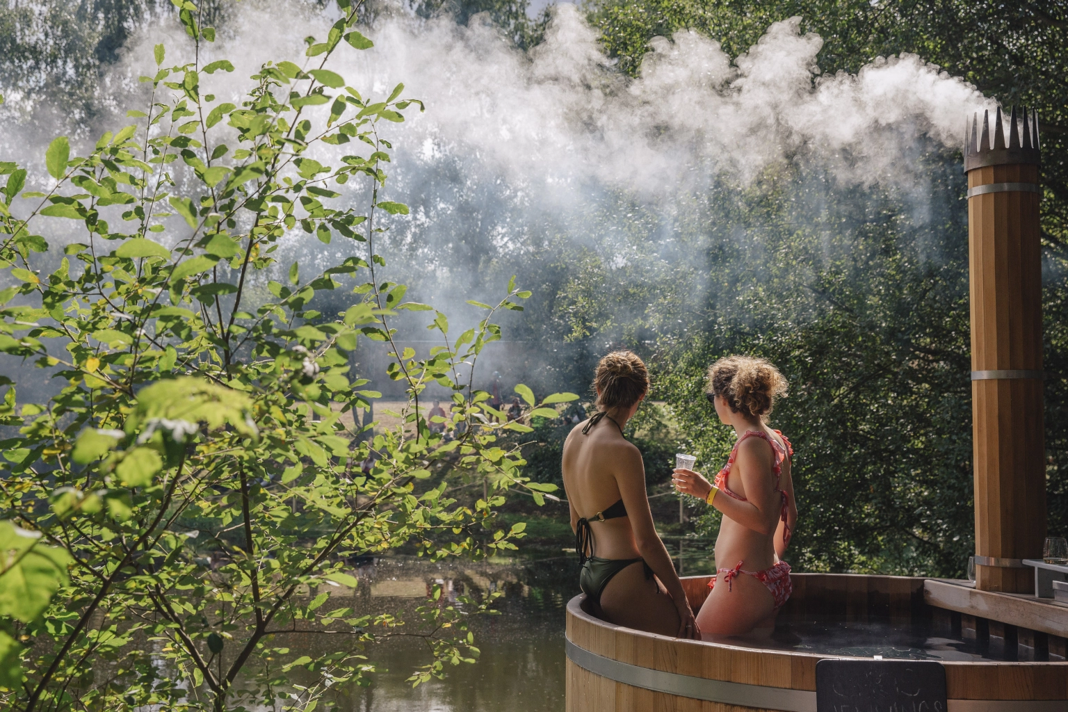 a photo of people in the hot tubs at lost village overlooking the water